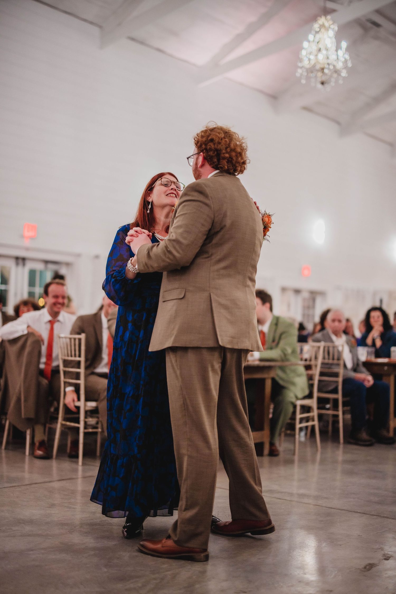 A couple shares a joyful moment while dancing at an elegant wedding reception venue.