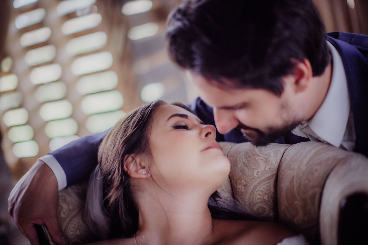 Close-up wedding portrait showcasing tender moments between newlyweds in a barn setting.
