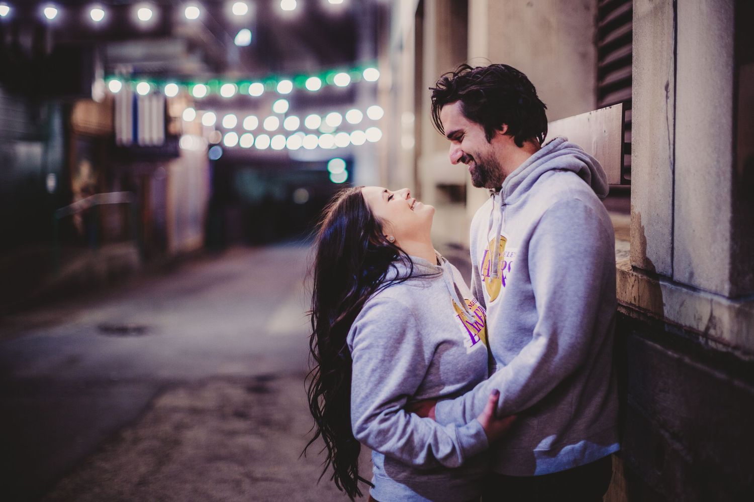 Romantic nighttime scene with string lights illuminating a couple's intimate moment.