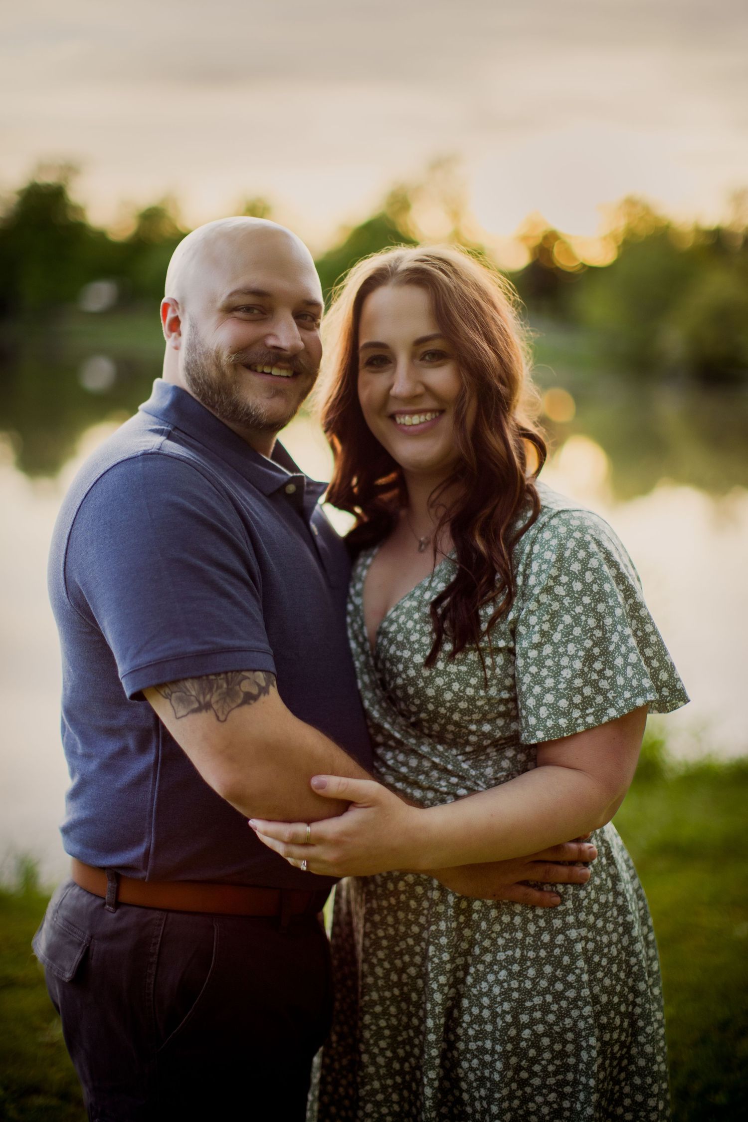 Sunset engagement photos show couple laughing together by waterfront.