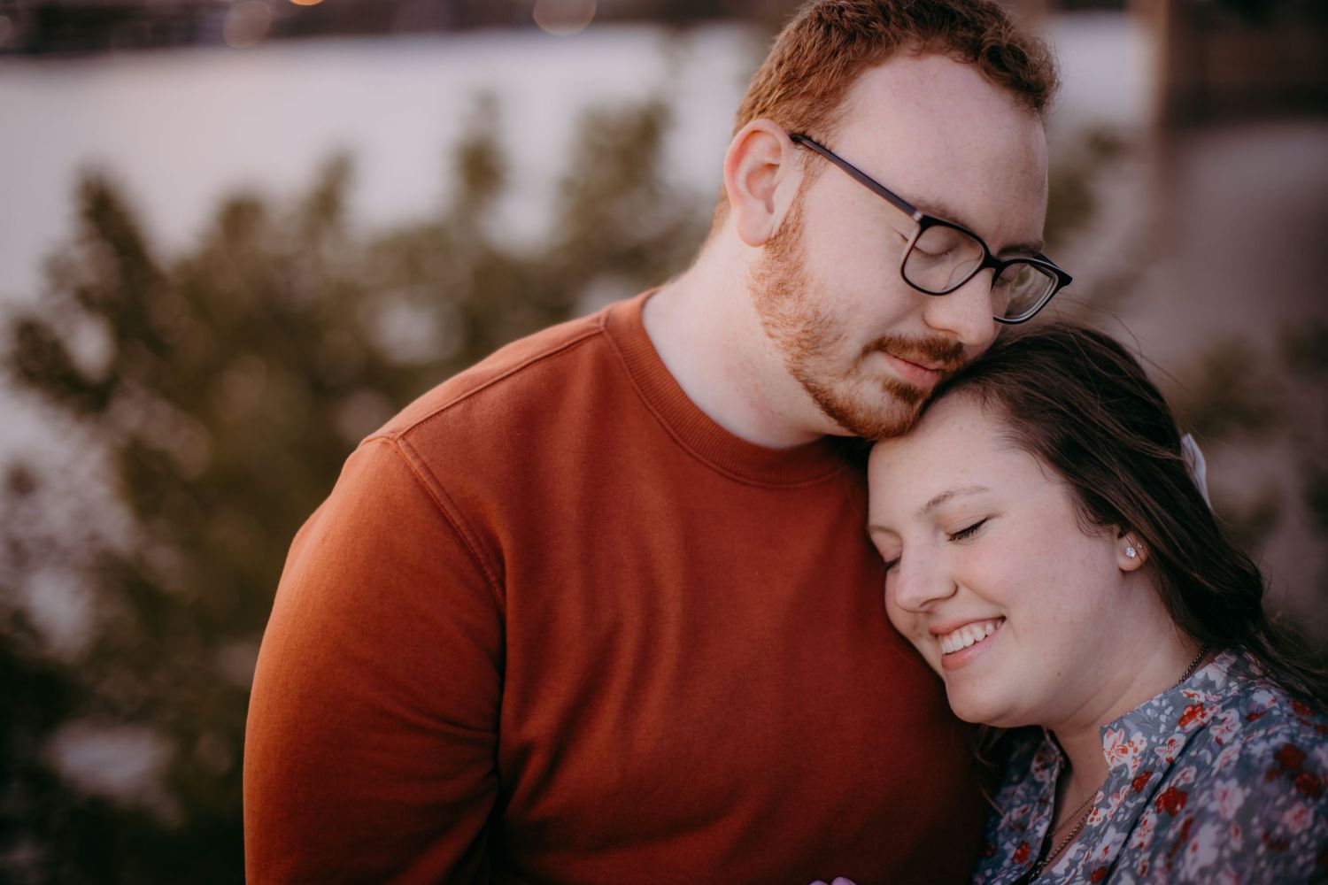 A couple embraces in warm evening light with soft focus creating an intimate mood.