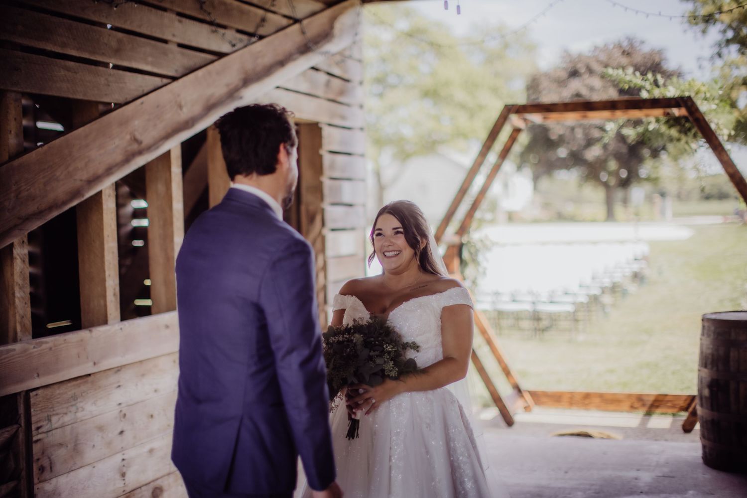 A couple shares an intimate first look during their rustic barn wedding ceremony.