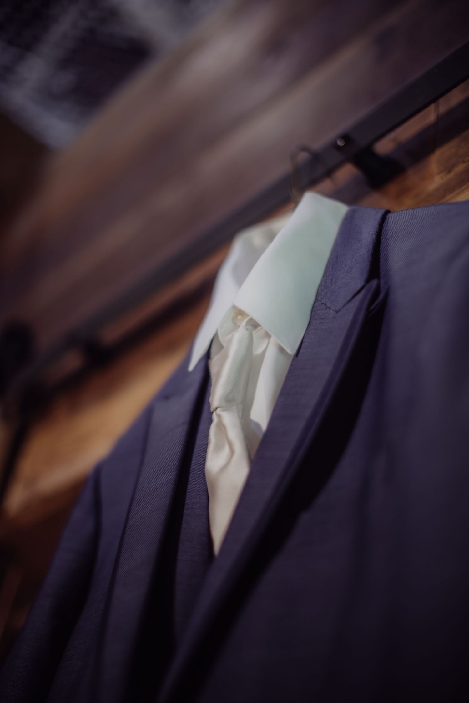 Close-up detail of navy blue suit jacket with mint green tie.