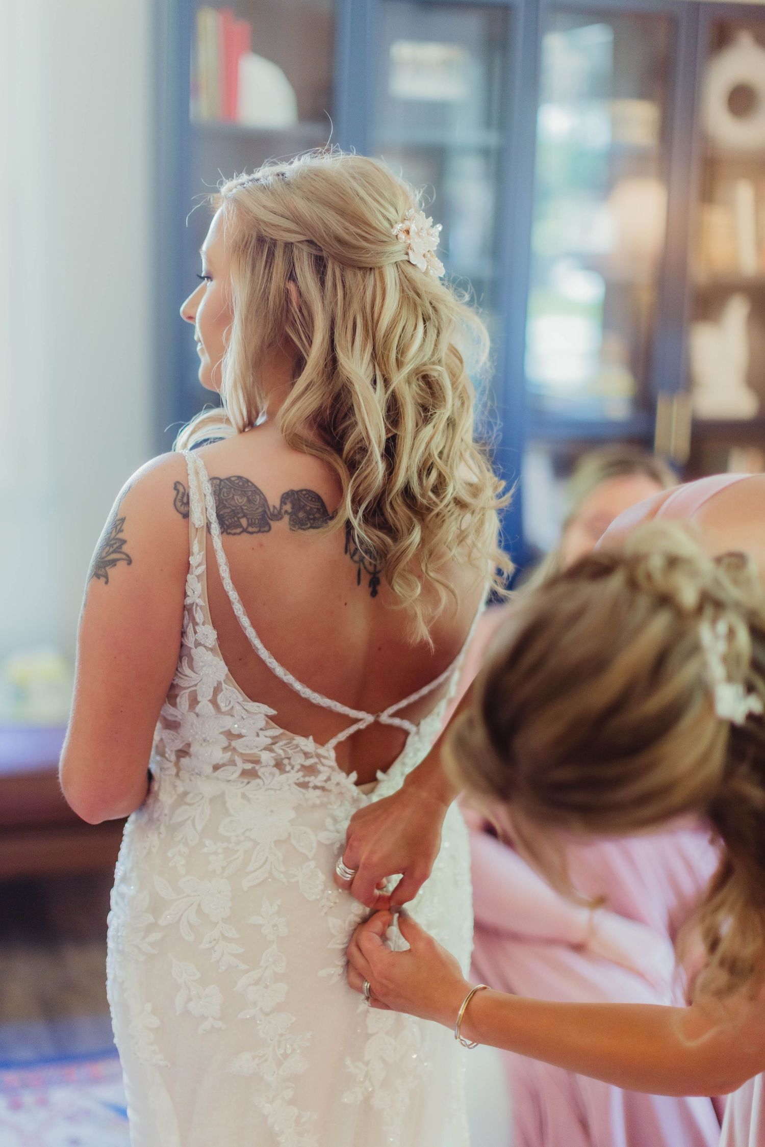 Detail shot of a lace wedding dress back with buttons during preparation.