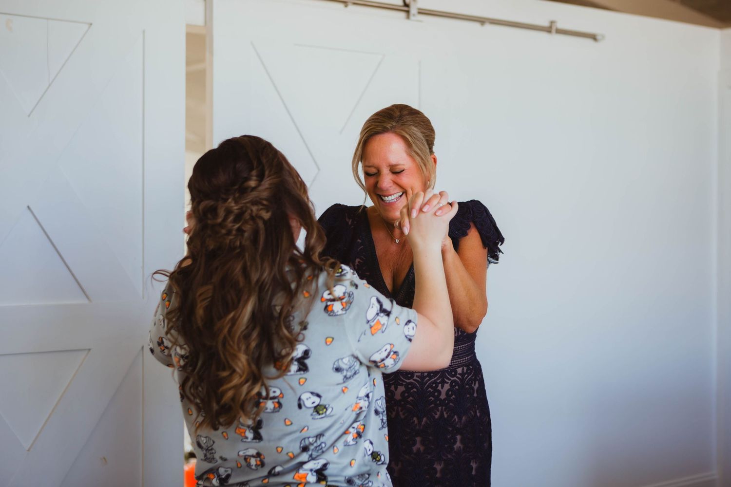 Emotional wedding first look moments captured in a modern white-walled venue.