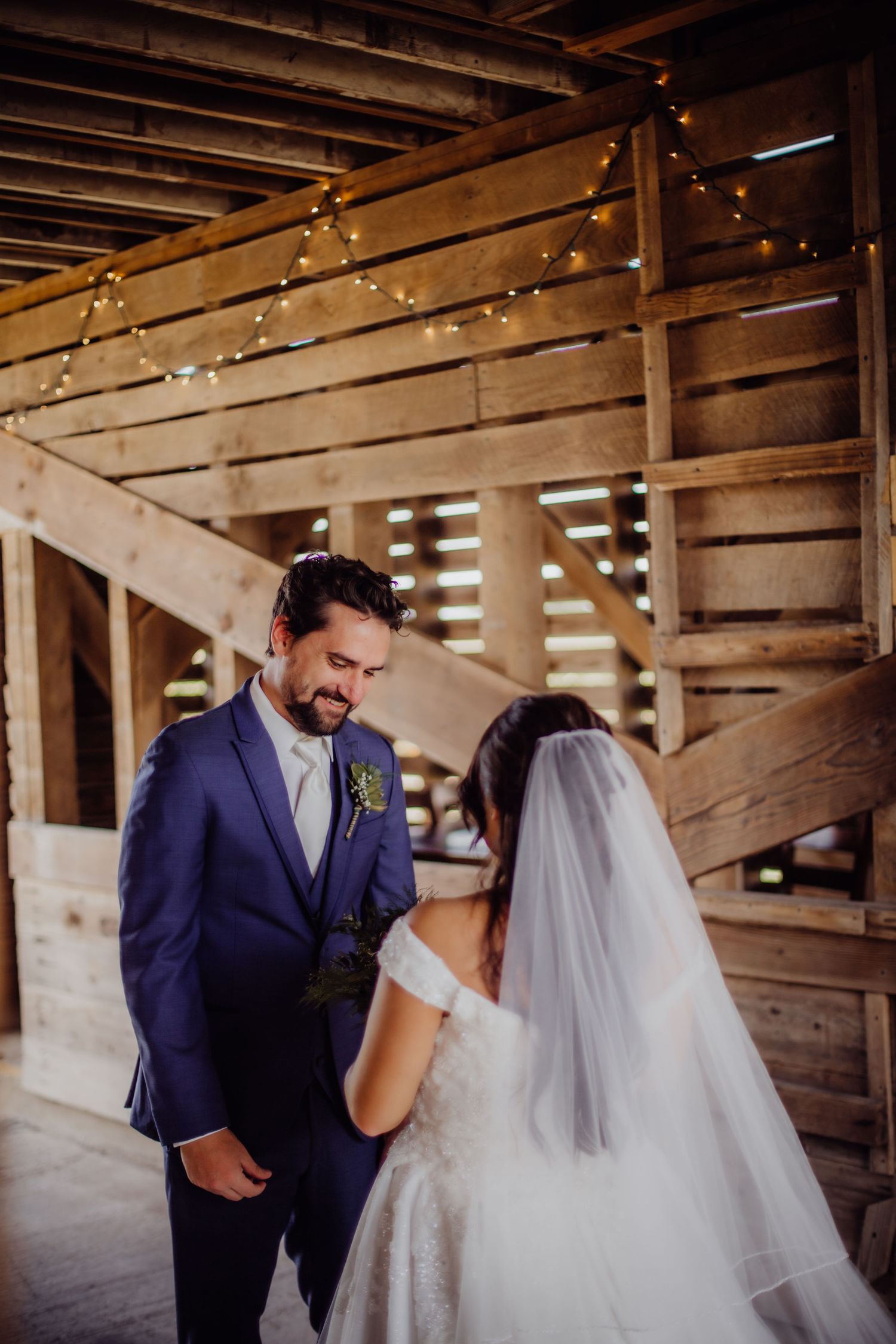 Joyful wedding first look captured in sequence inside a charming wooden barn.