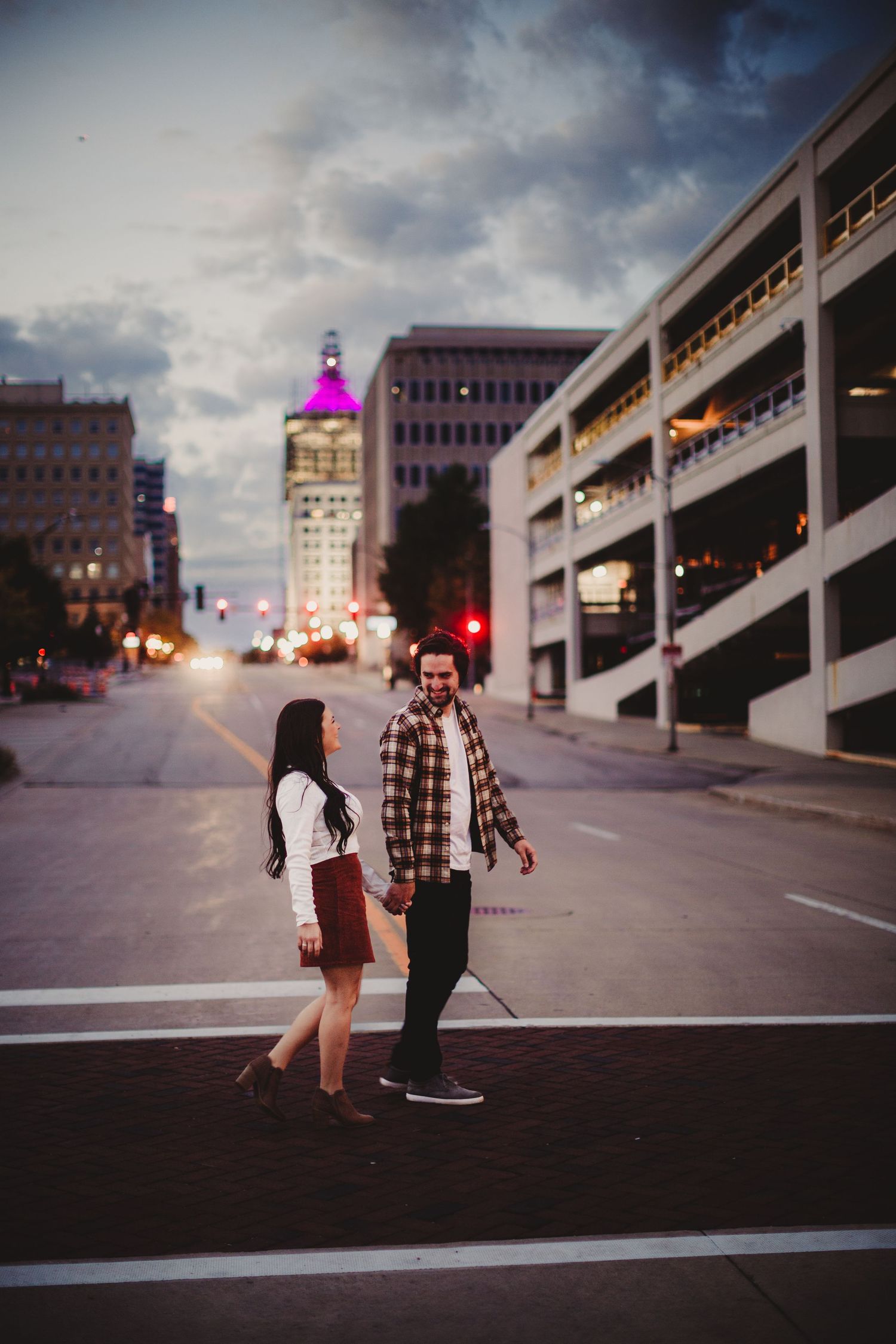 Urban engagement photoshoot in a city parking structure at dusk.