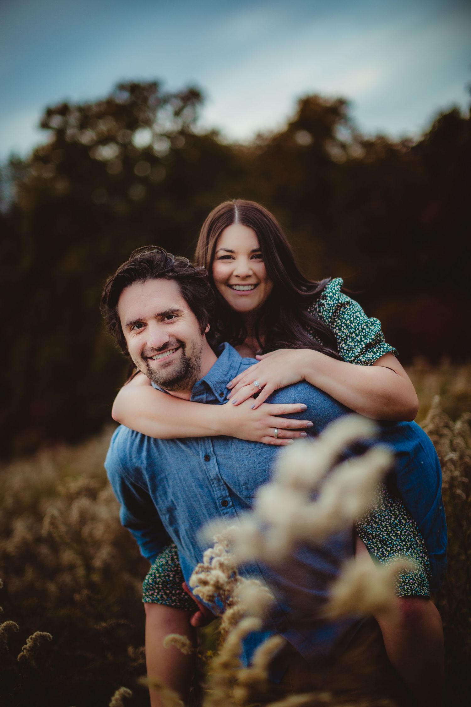 Playful couple in casual attire having fun in a golden autumn field.