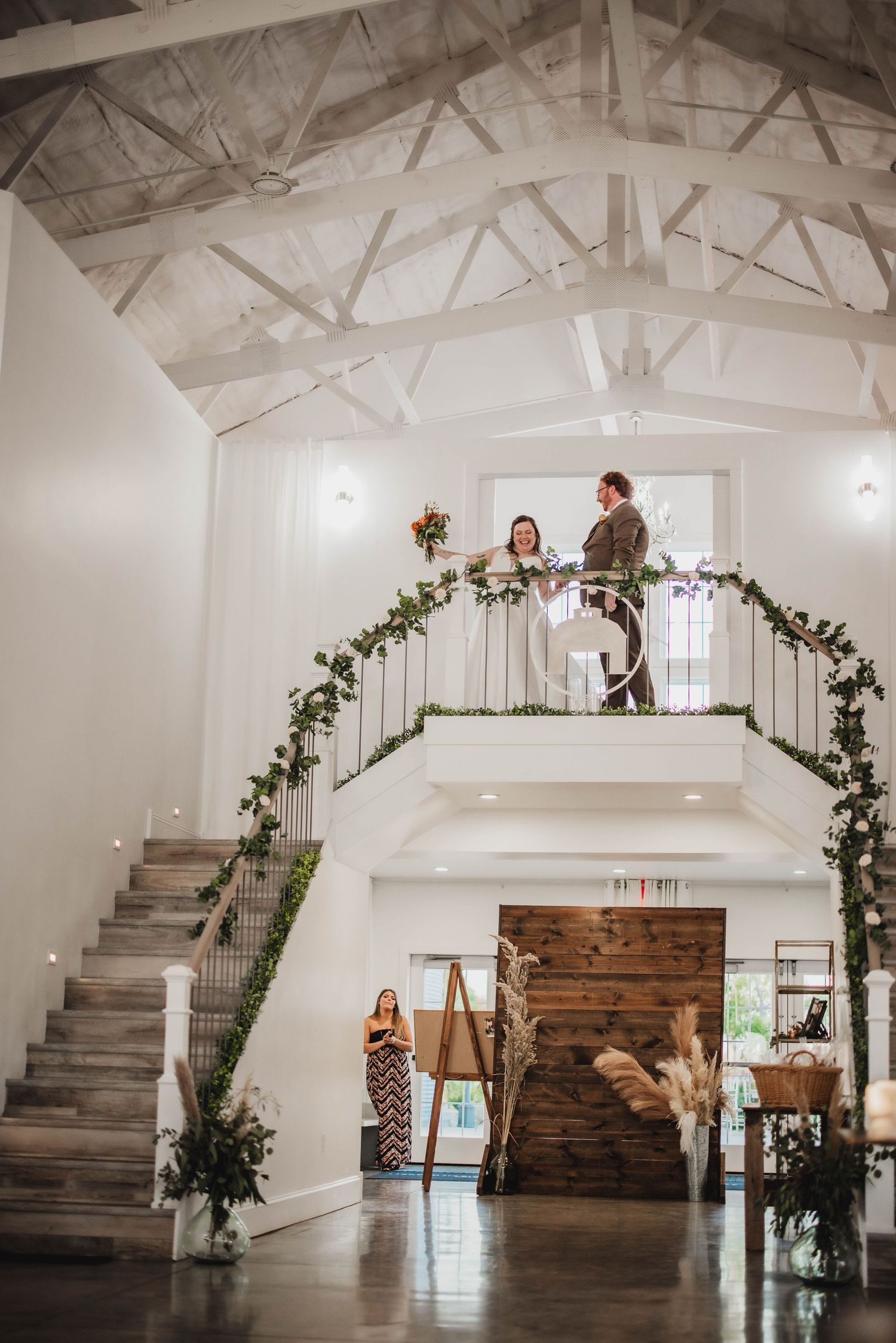 Elegant white wedding venue interior showcasing architectural details and decorative greenery garlands.