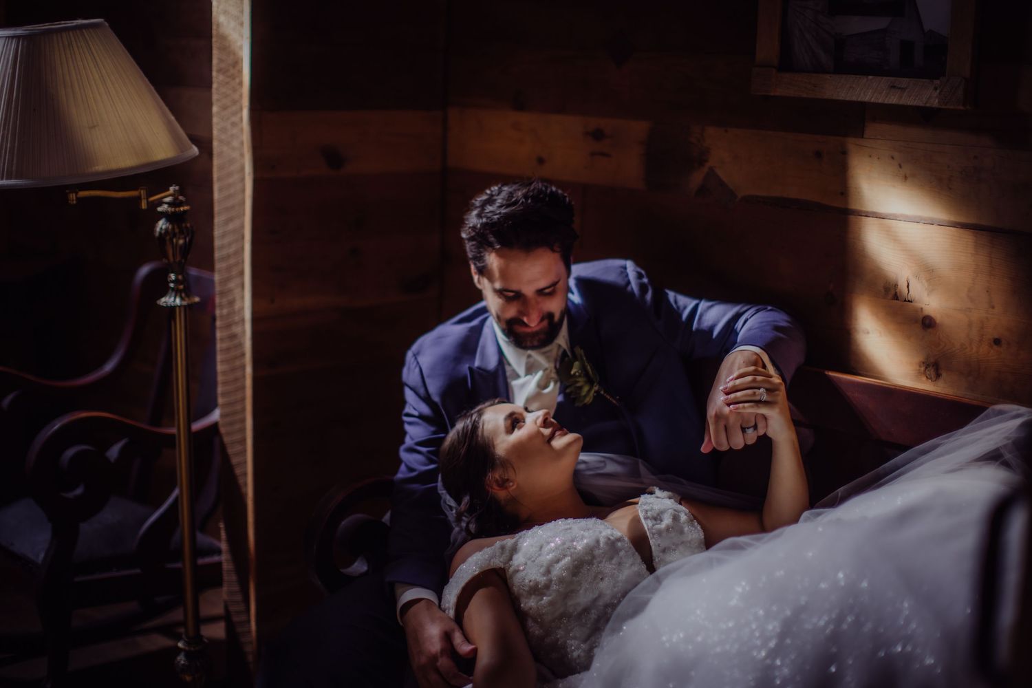 Dramatic wedding photography with warm lighting in a rustic setting.