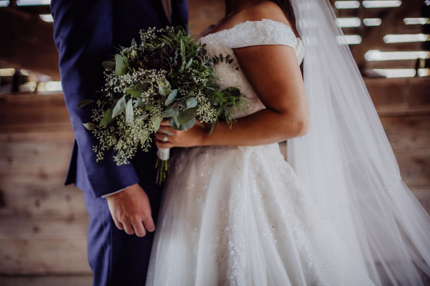 Romantic wedding photography showing intimate moments in a rustic barn venue.