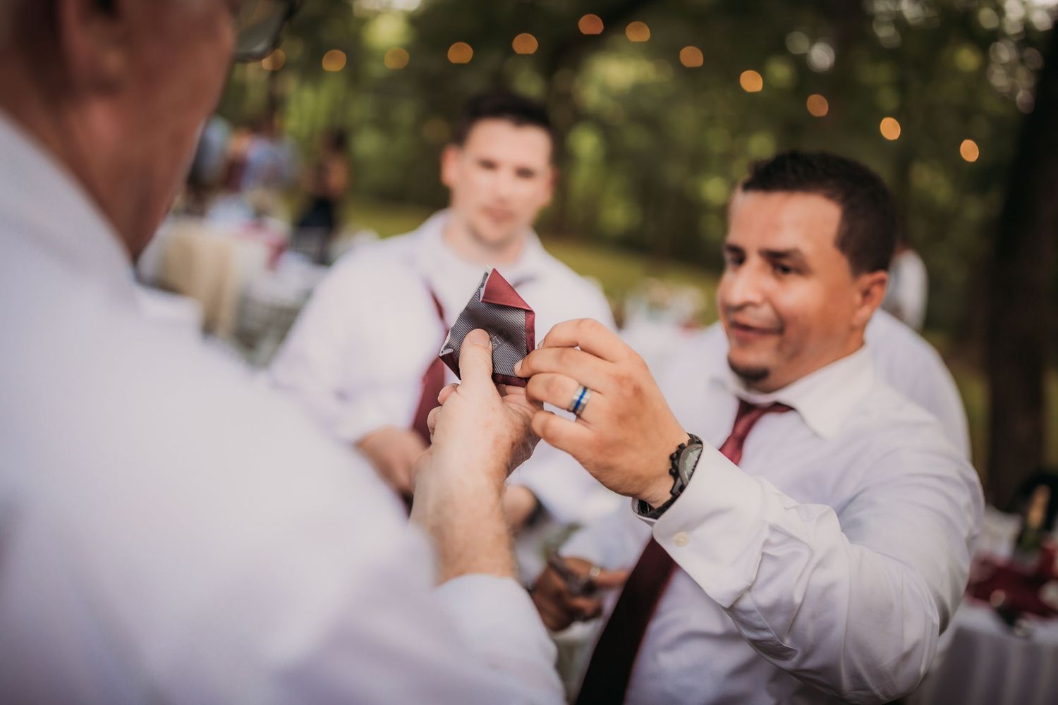People in formal attire share an excited moment during an outdoor celebration.