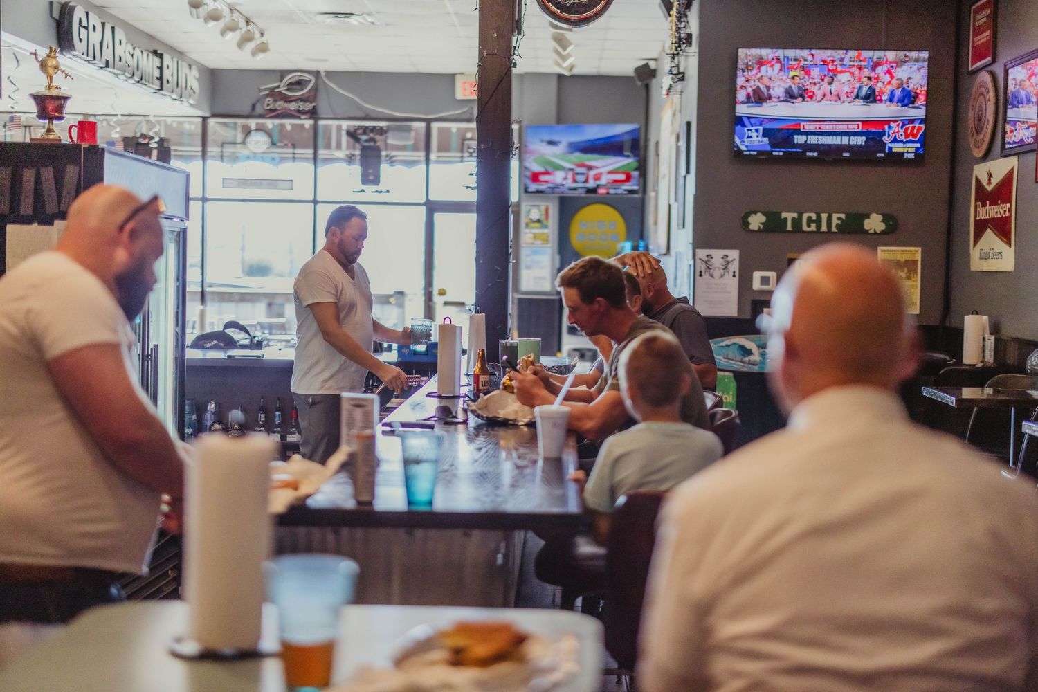 Casual dining scene inside a sports bar with TVs and customers.