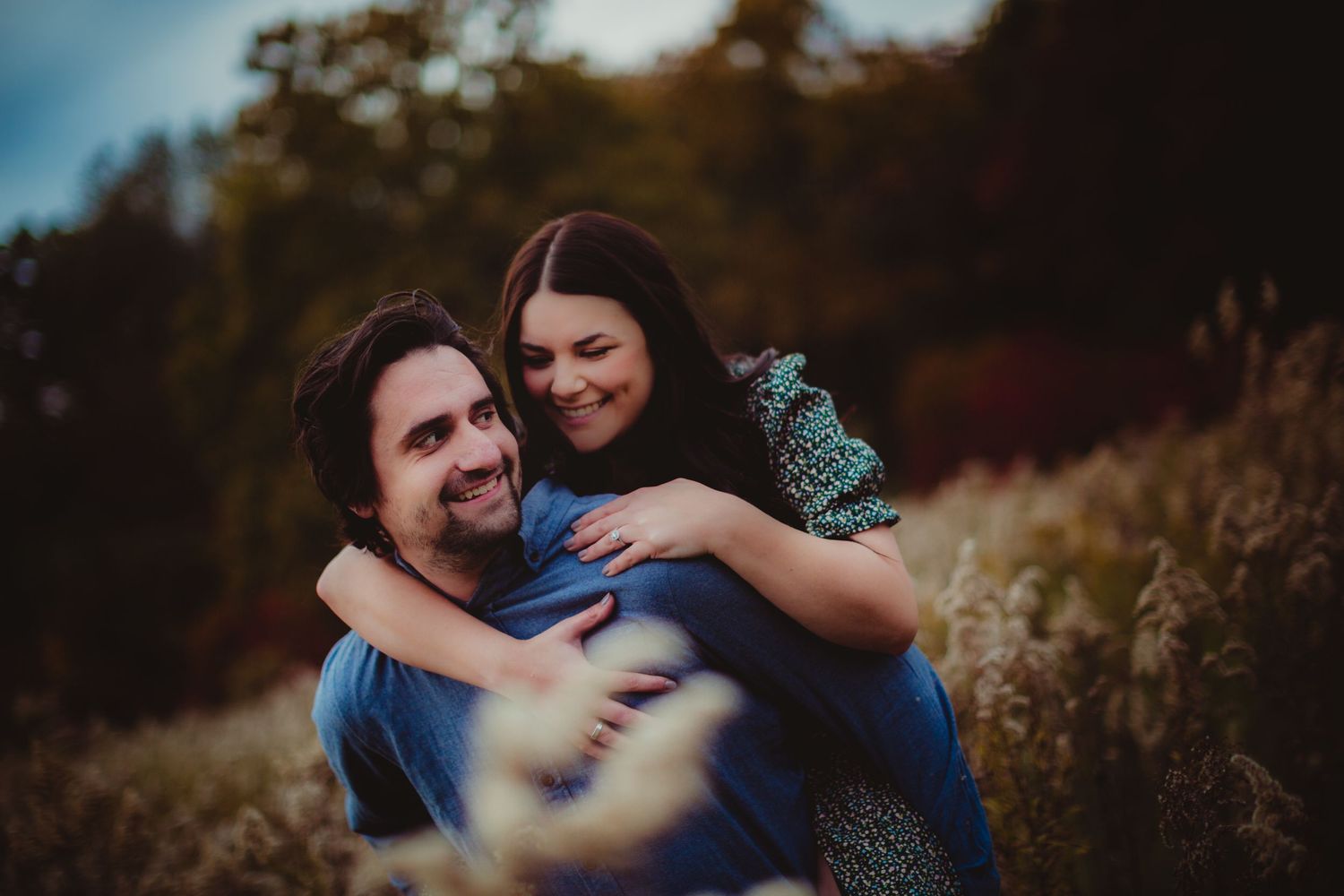 Romantic couple enjoying a tender moment in a field during golden hour.