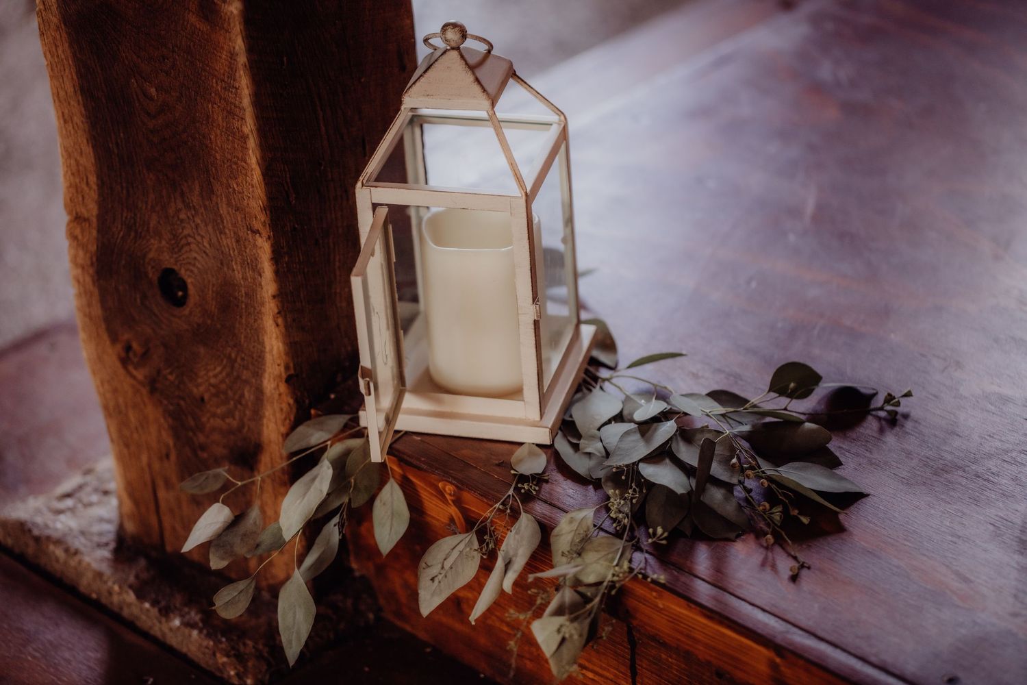 Wedding reception decor featuring lantern centerpieces and eucalyptus arrangements.