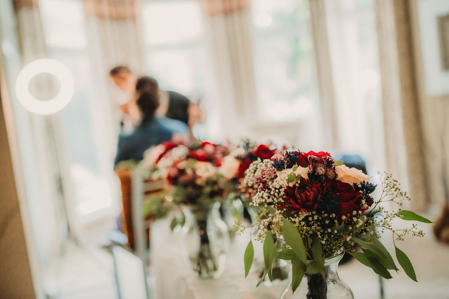 Elegant wedding reception venue with soft natural lighting and floral centerpieces.