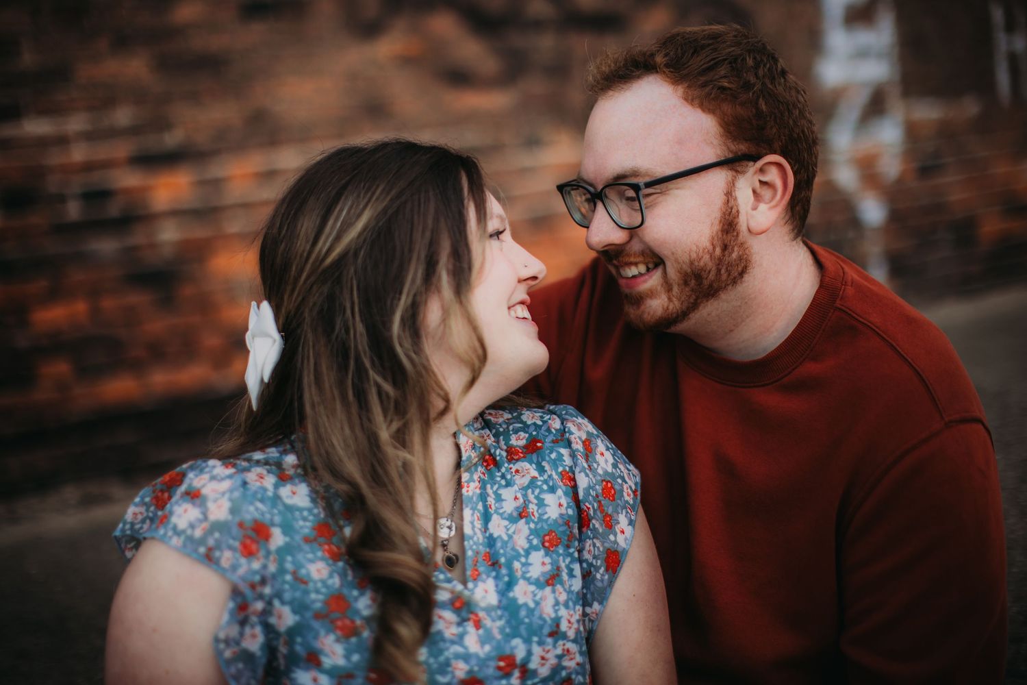 A couple shares laughter during their urban portrait session.