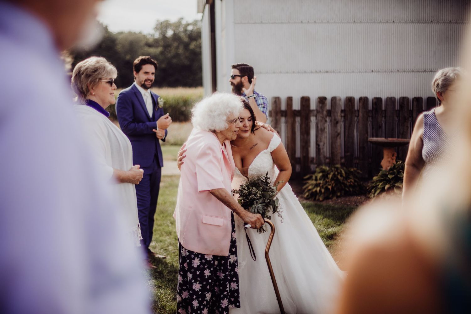 Guests celebrate during an outdoor wedding reception on a sunny afternoon.