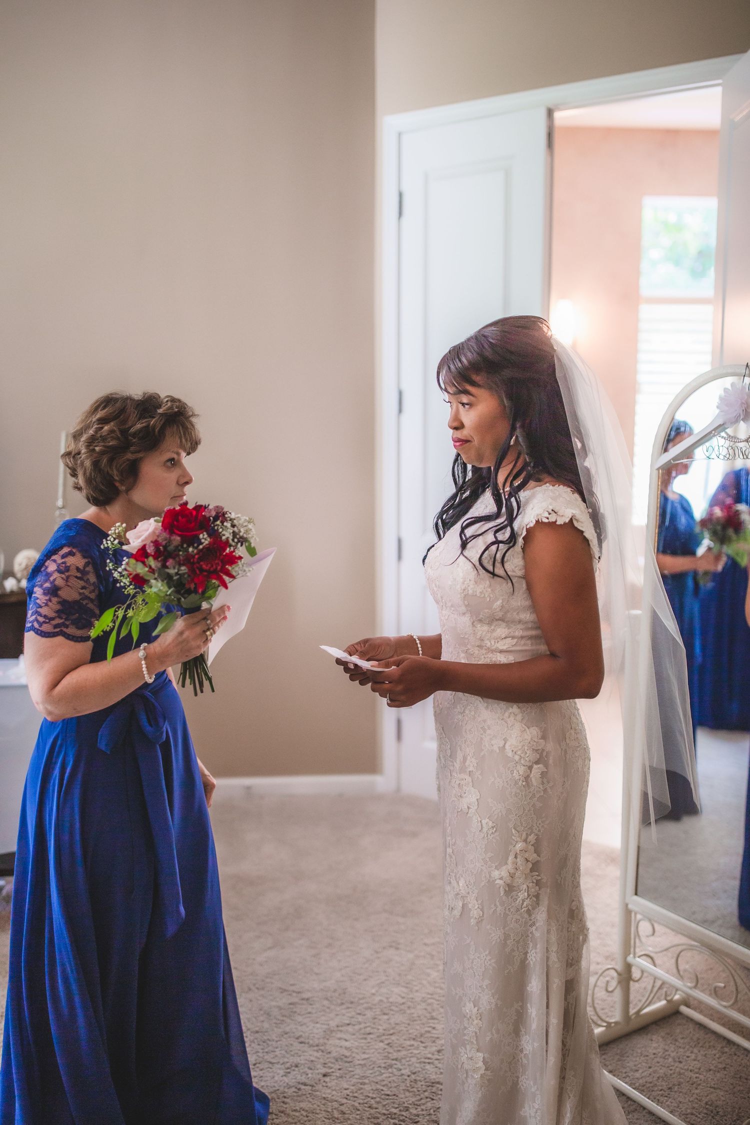 Wedding preparations scene with attendants in royal blue dresses helping with the bridal gown.