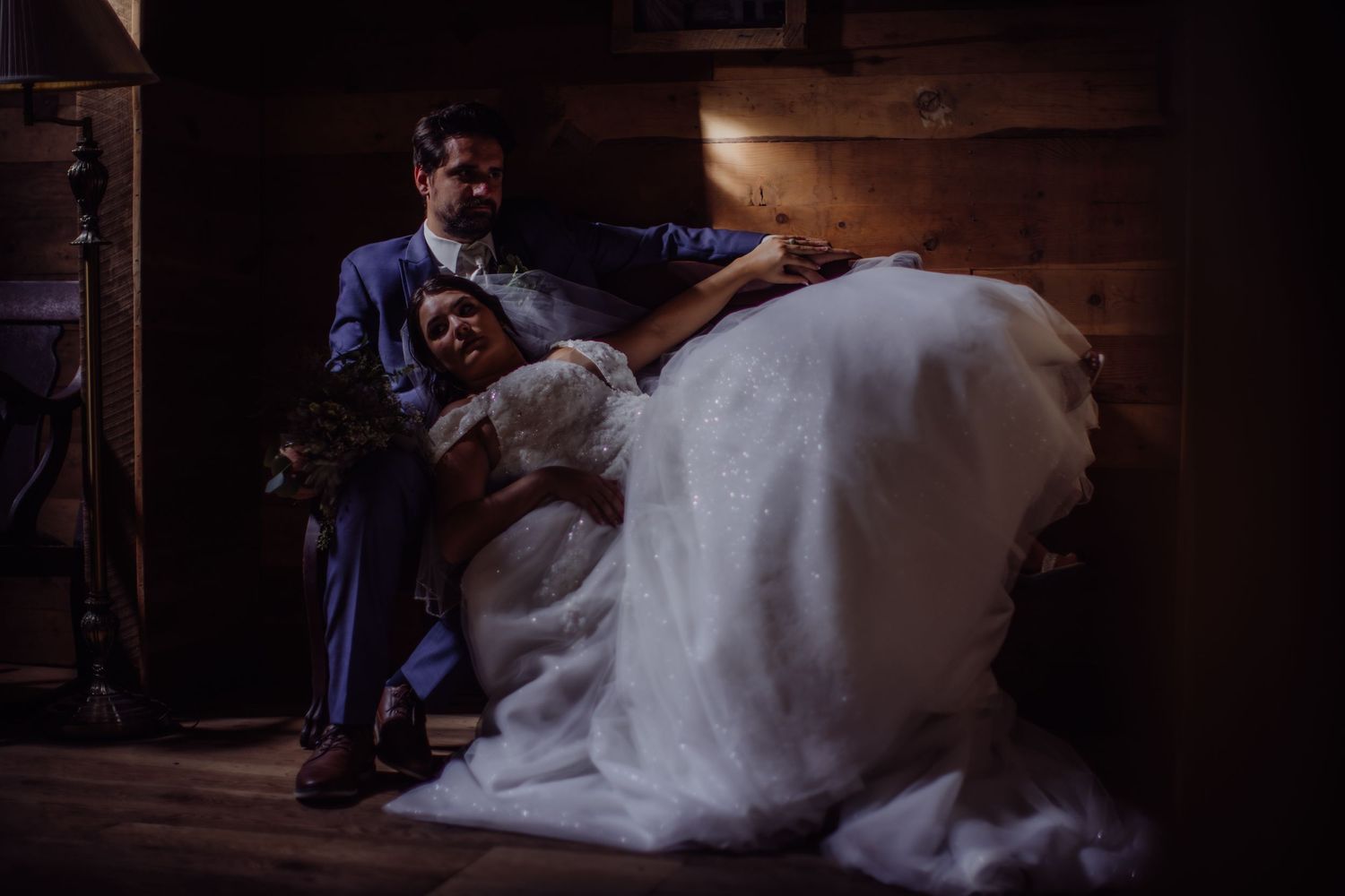 Artistic wedding photo with dramatic shadows and lighting on wooden staircase.