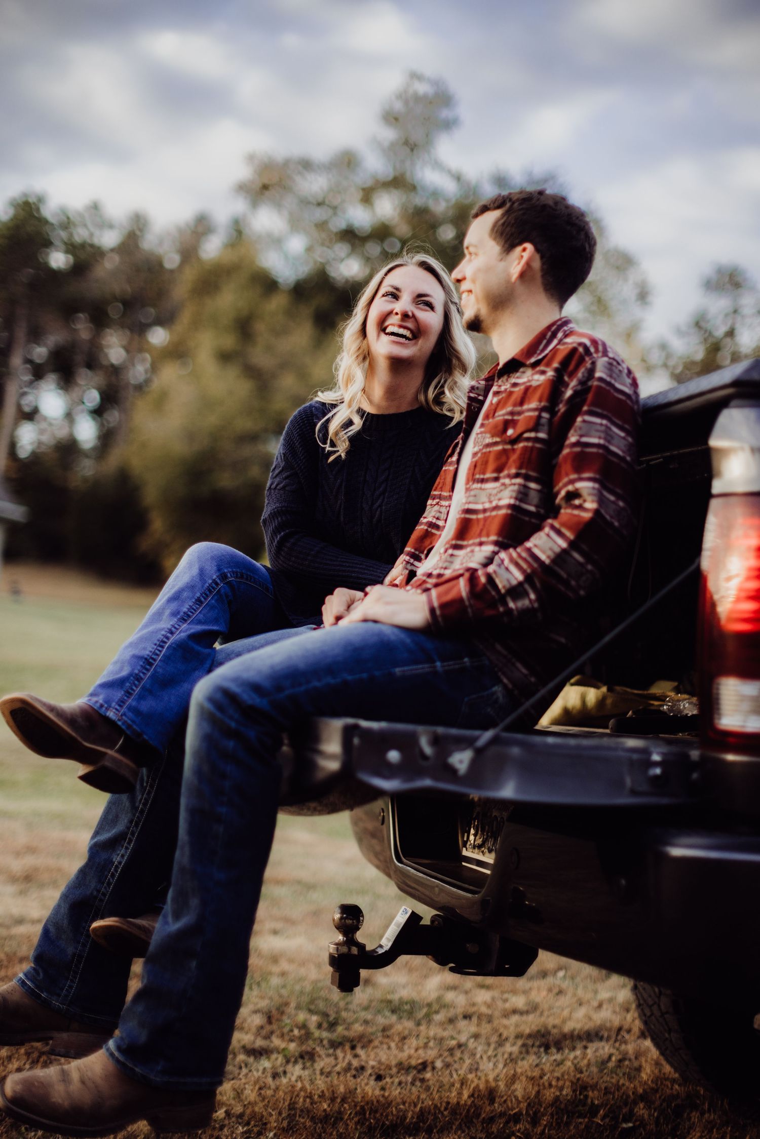 Joyful moment shared on back of pickup truck in field setting.
