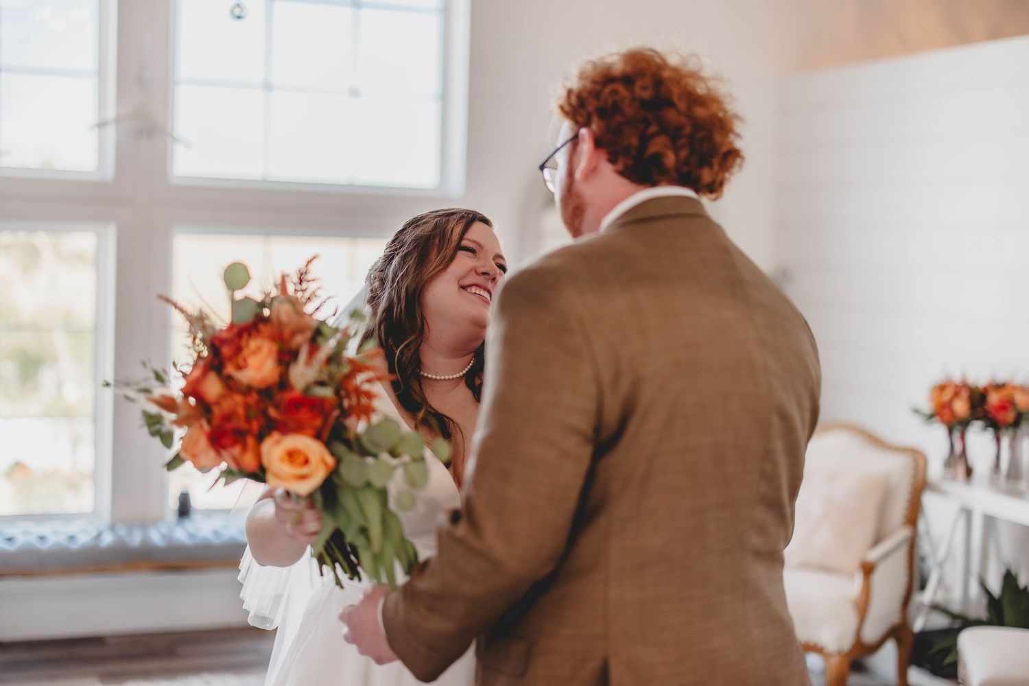Tender interaction between wedding couple surrounded by warm autumn colors and natural light.
