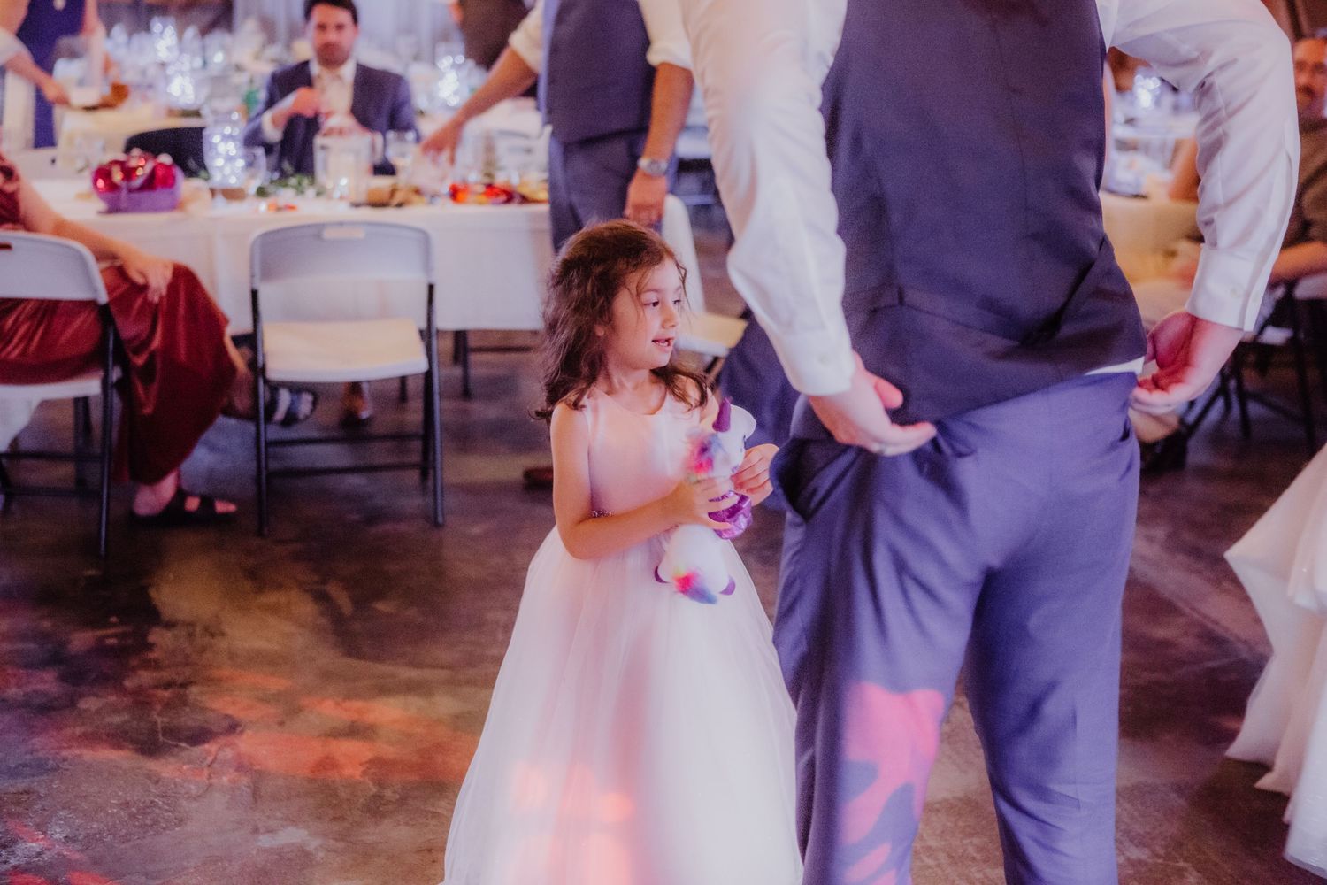 Couples dancing together at a rustic barn wedding reception with string lights overhead.