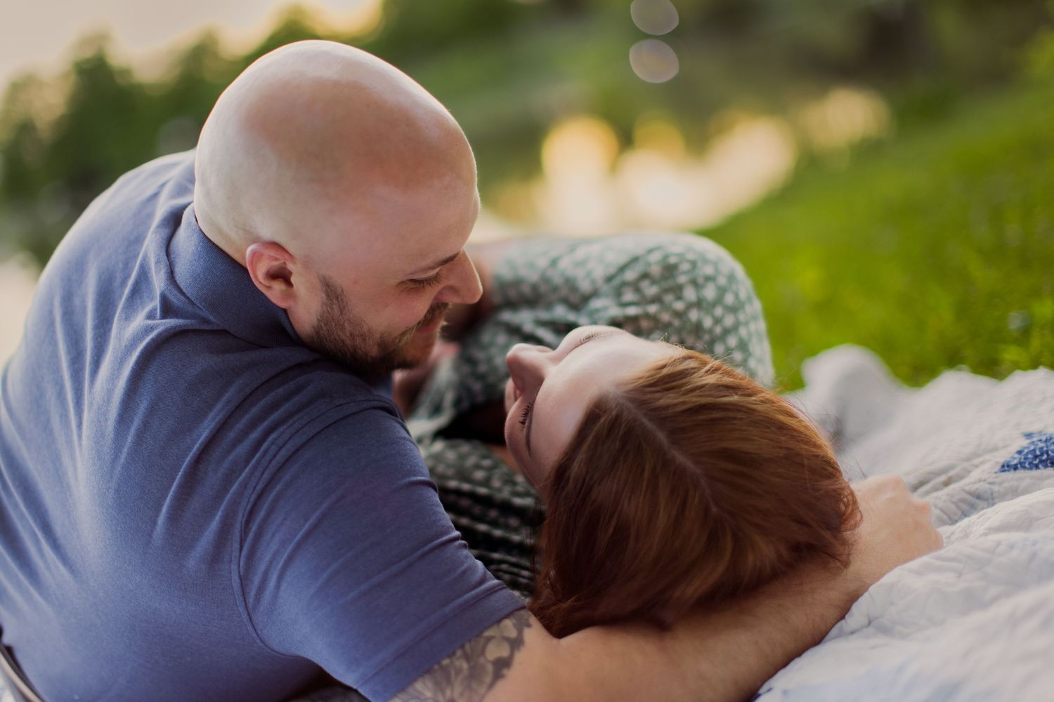 Two people sharing an intimate moment during a lakeside photo session.