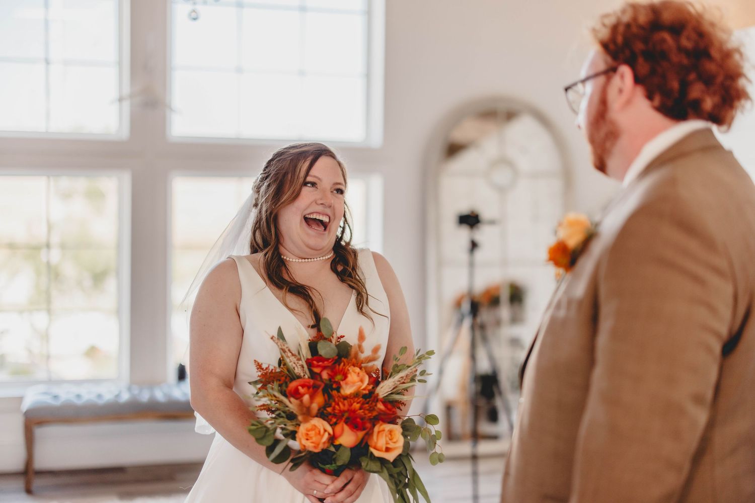 Candid moment between couple at wedding with warm brown and orange autumn color palette.