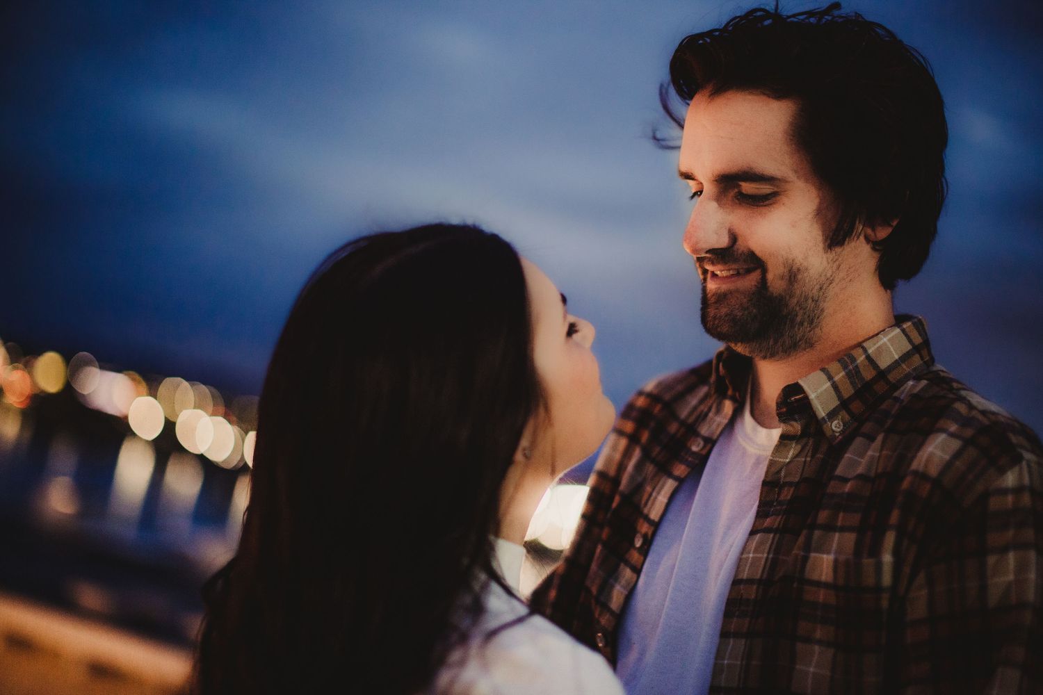 A couple shares a tender moment together outside during blue hour.