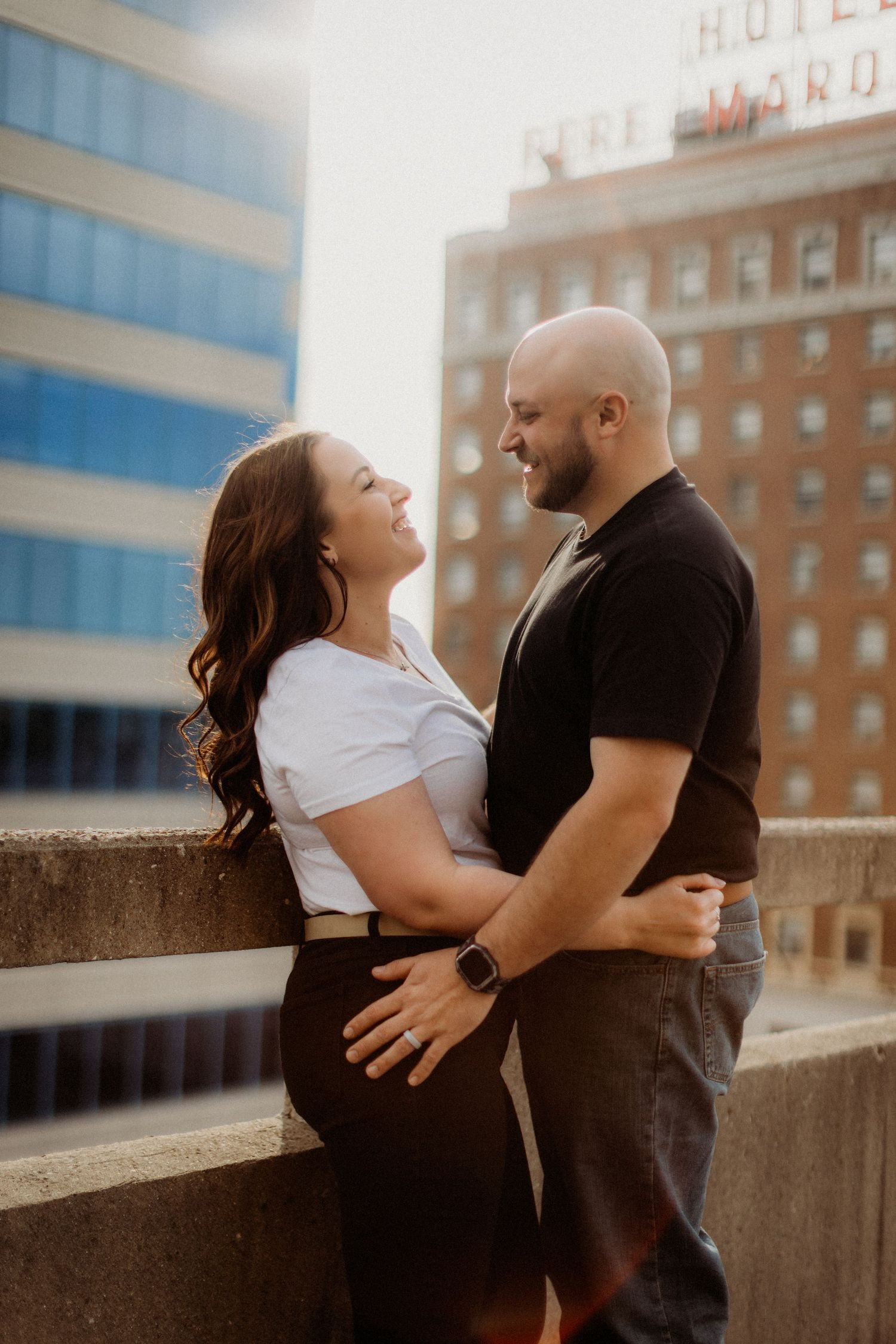A romantic couple embraces on a city rooftop during their engagement photoshoot.