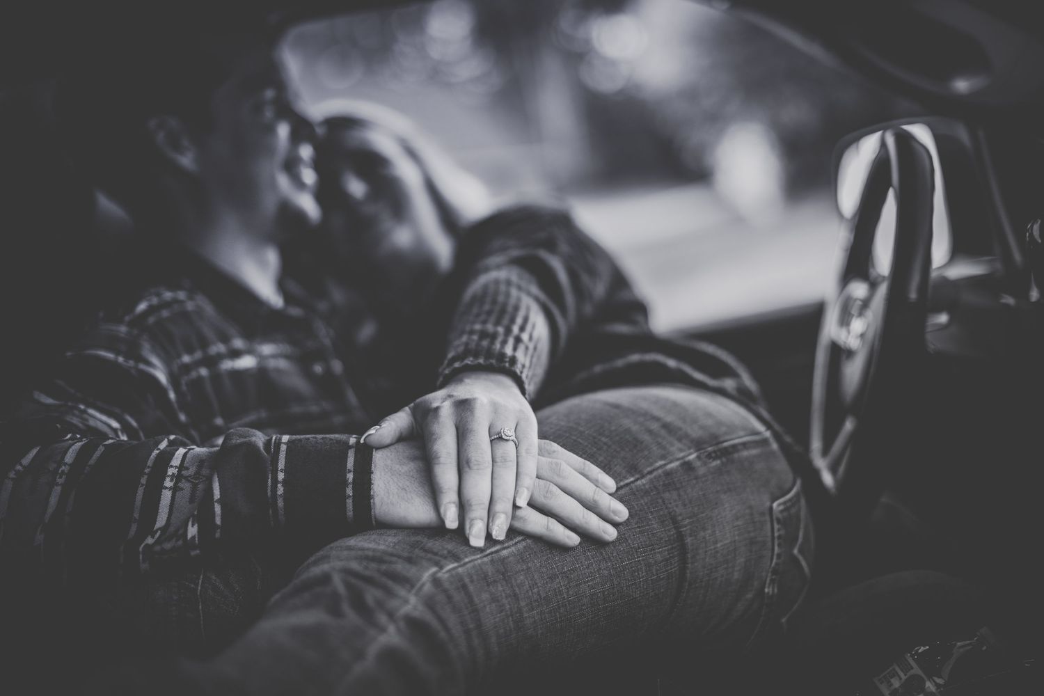 Black and white intimate moment captured in vehicle.