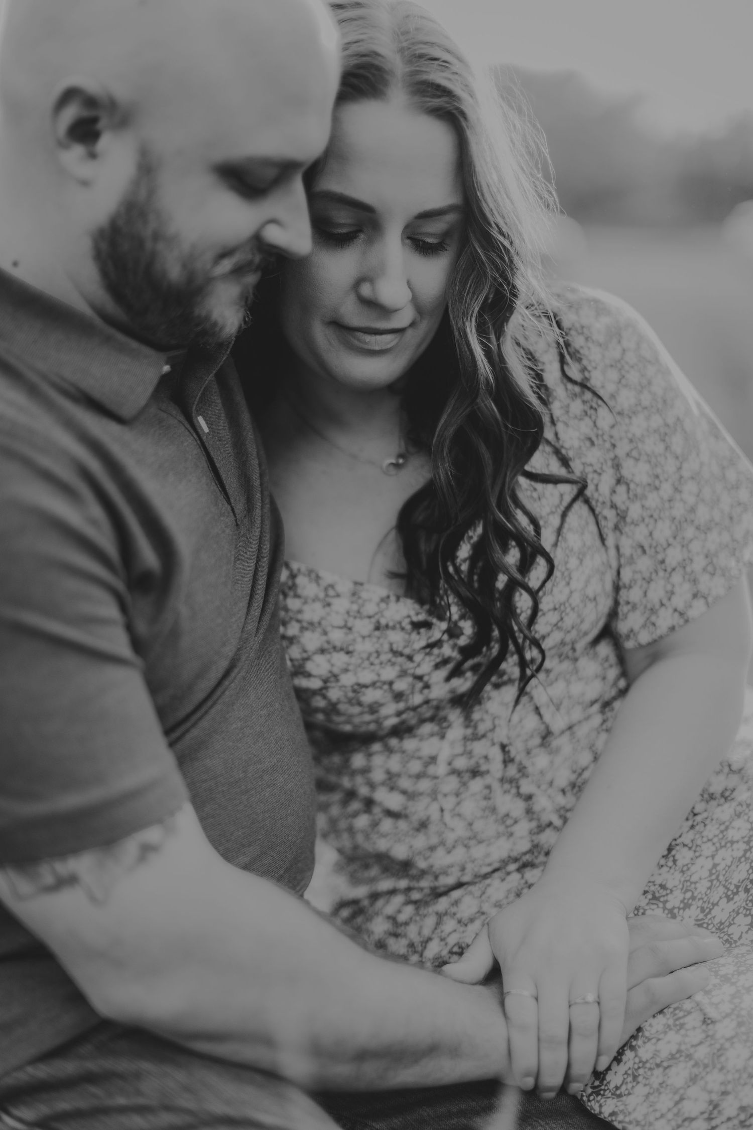An intimate black and white portrait of a couple holding hands during their engagement session.