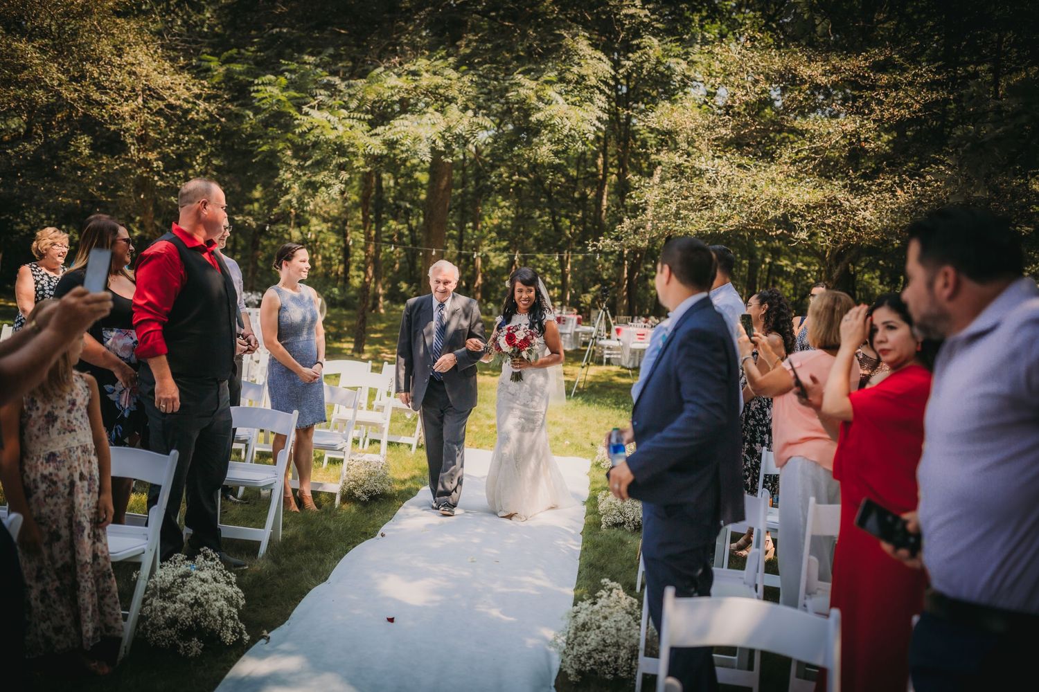 Wedding celebration in a natural garden setting with guests enjoying the outdoor atmosphere.
