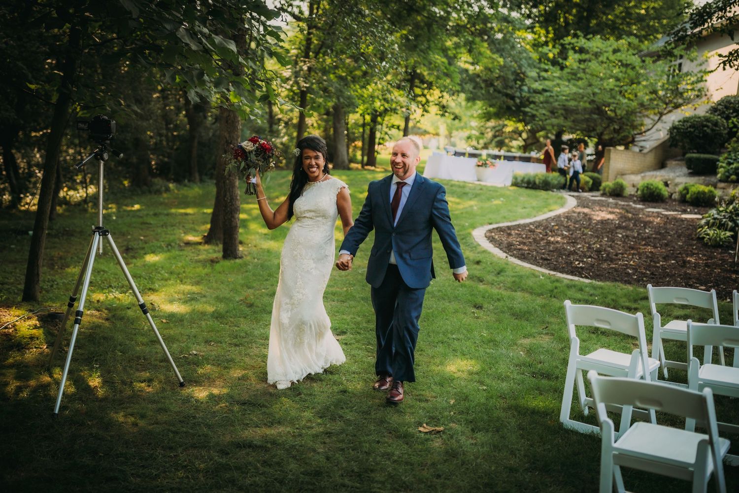 Scenic outdoor wedding venue with white ceremony chairs arranged on a grassy lawn.
