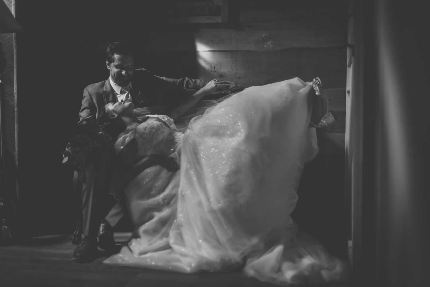 Close-up shot of newlyweds in a tender embrace with dramatic lighting.