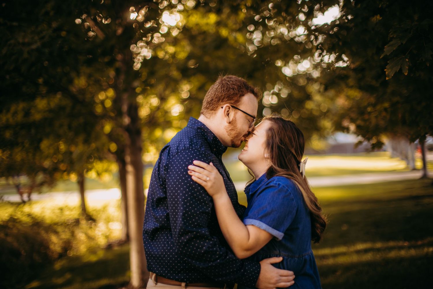 Gentle embrace photographed in warm evening light with natural backdrop.