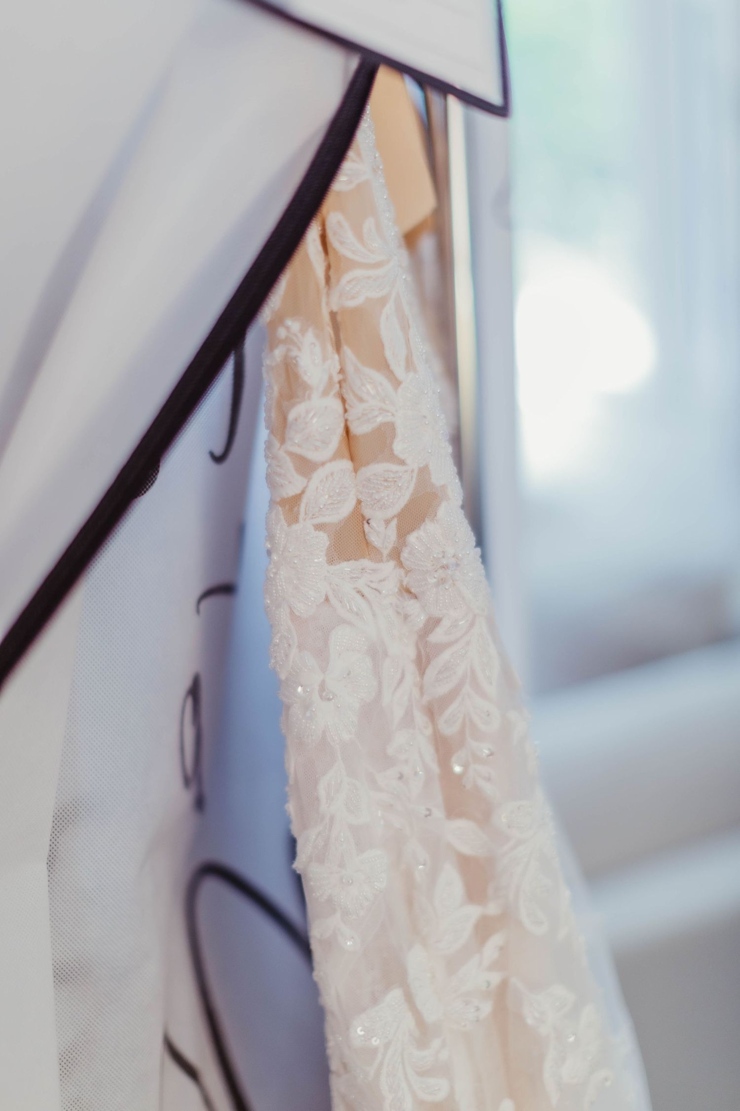 Close-up detail of delicate lace pattern on ivory wedding dress fabric.