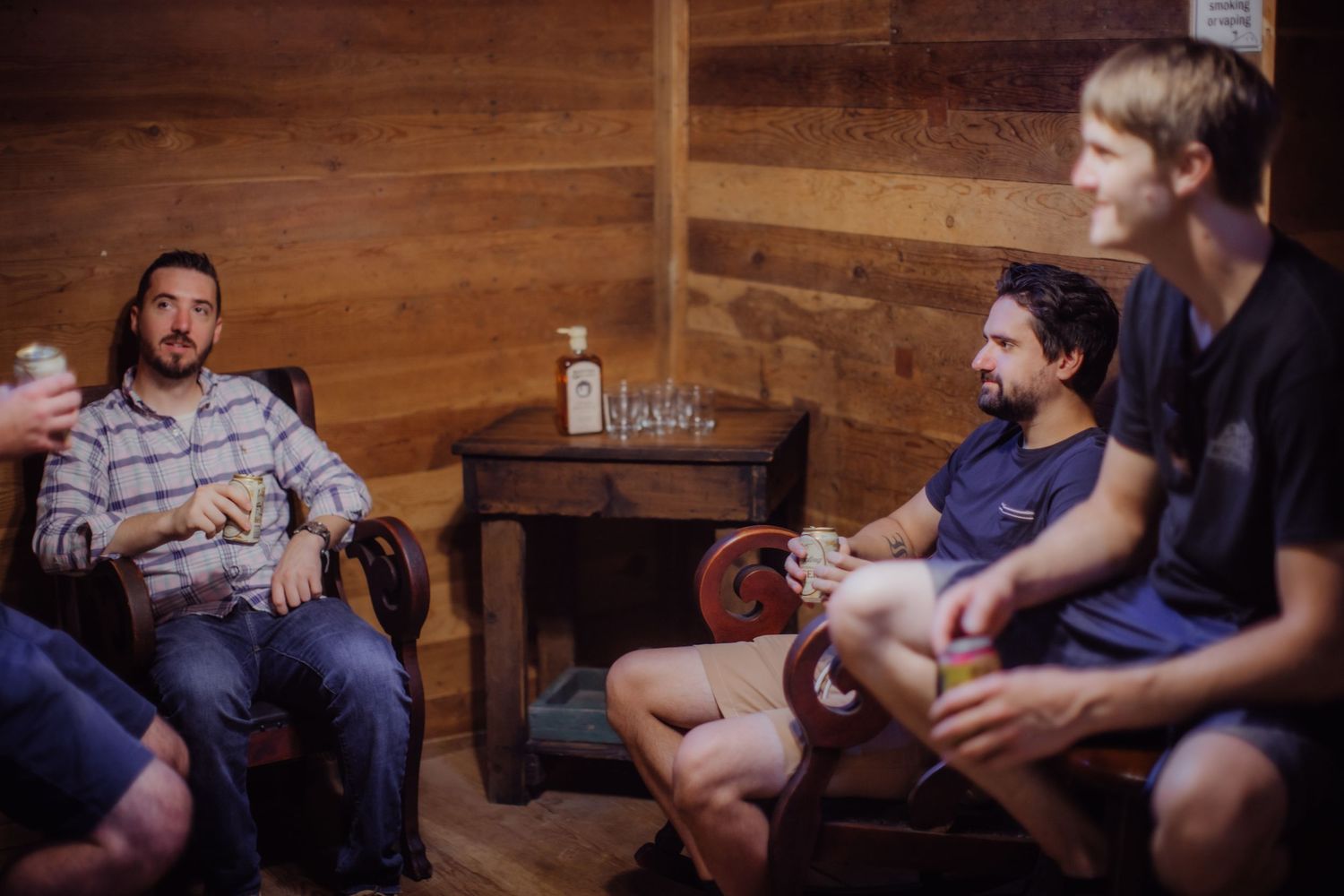 Group gathered in rustic wood-paneled room for casual gathering.