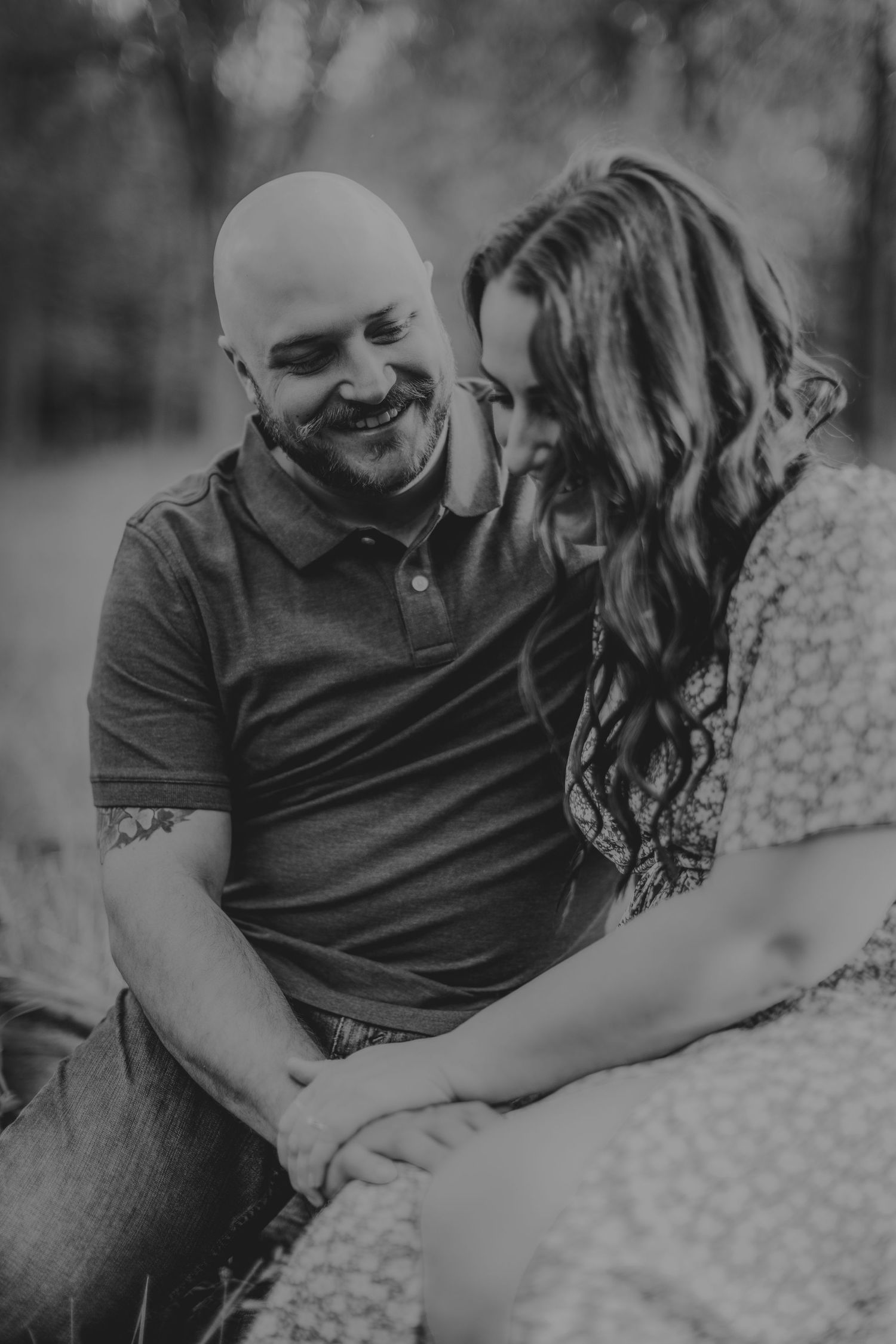 Romantic black and white portrait of a couple sharing an intimate moment outdoors.