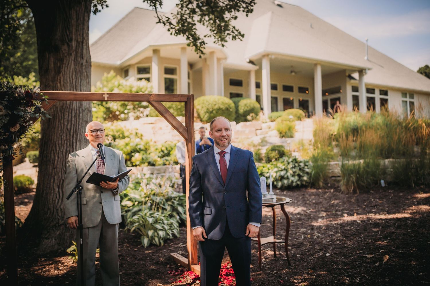Garden venue decorated for an outdoor wedding with elegant white floral arrangements.