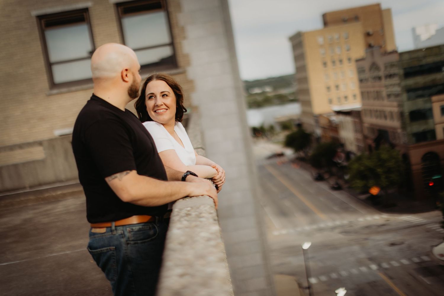 Urban couple posing together by a downtown city street.