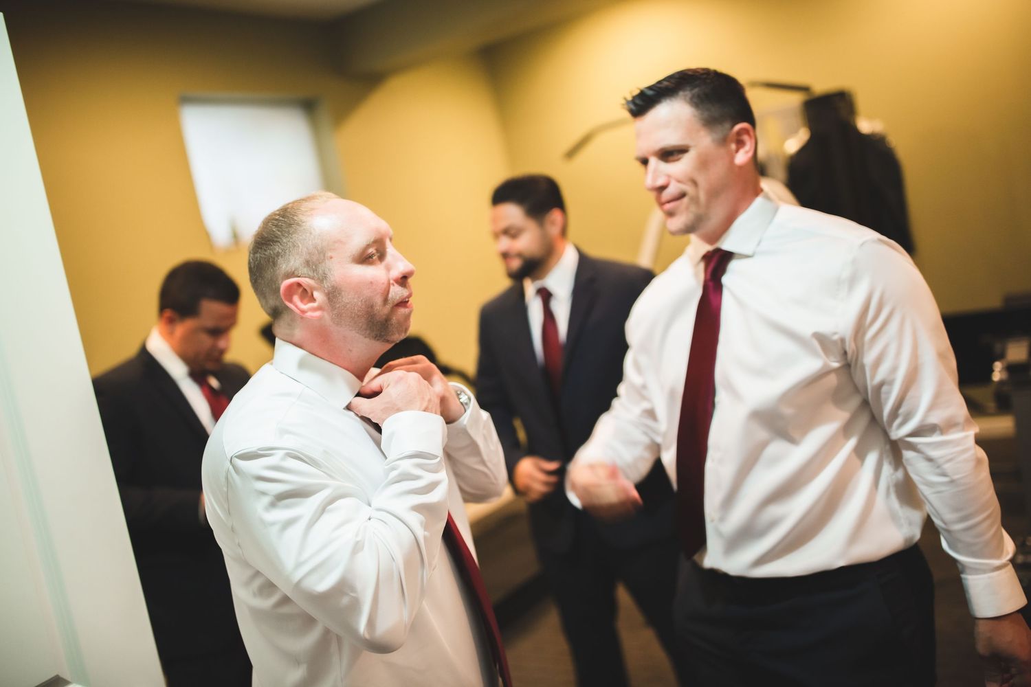 People in business attire share a moment while preparing in a room.