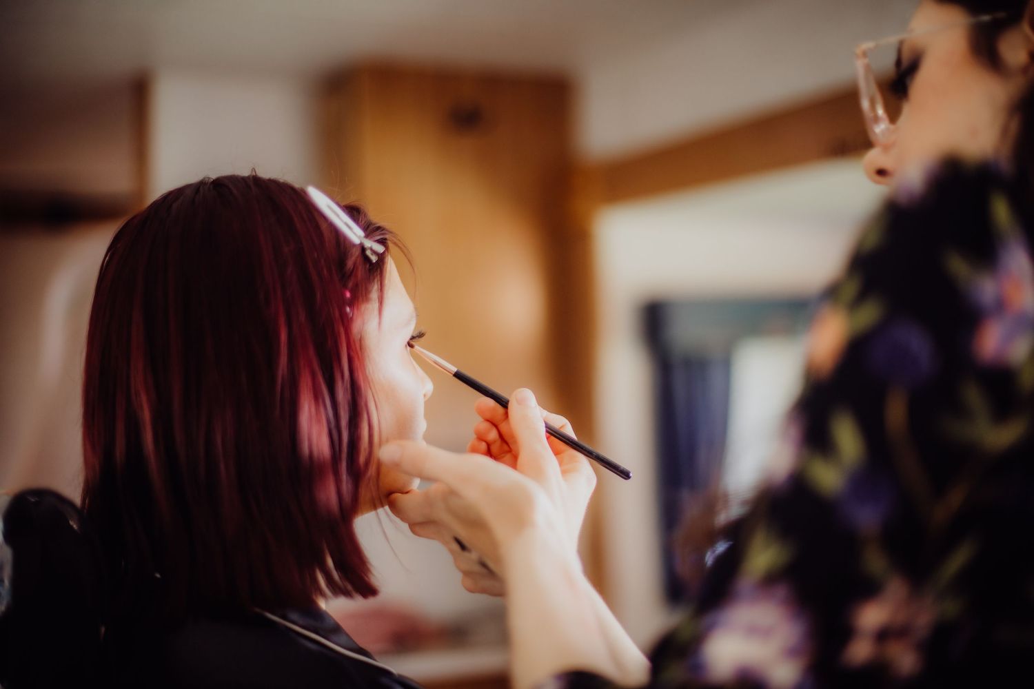 A makeup artist applies lipstick during a beauty preparation session.