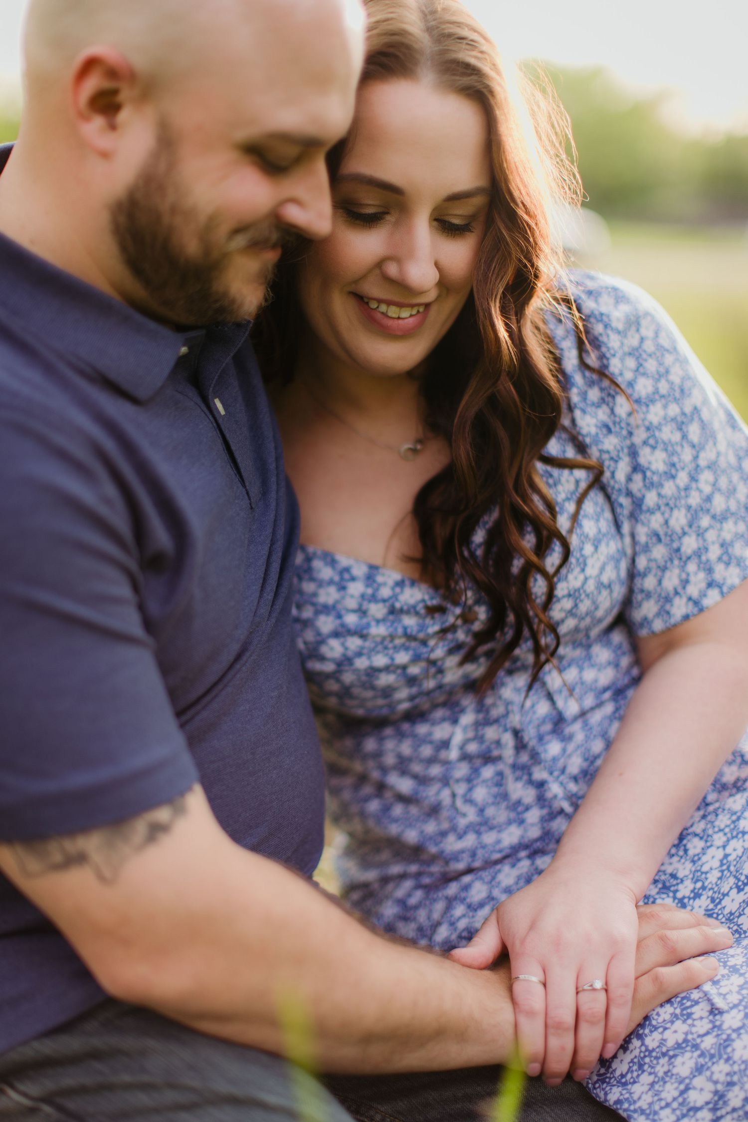 A candid moment between a couple sharing laughter during their outdoor photo session.