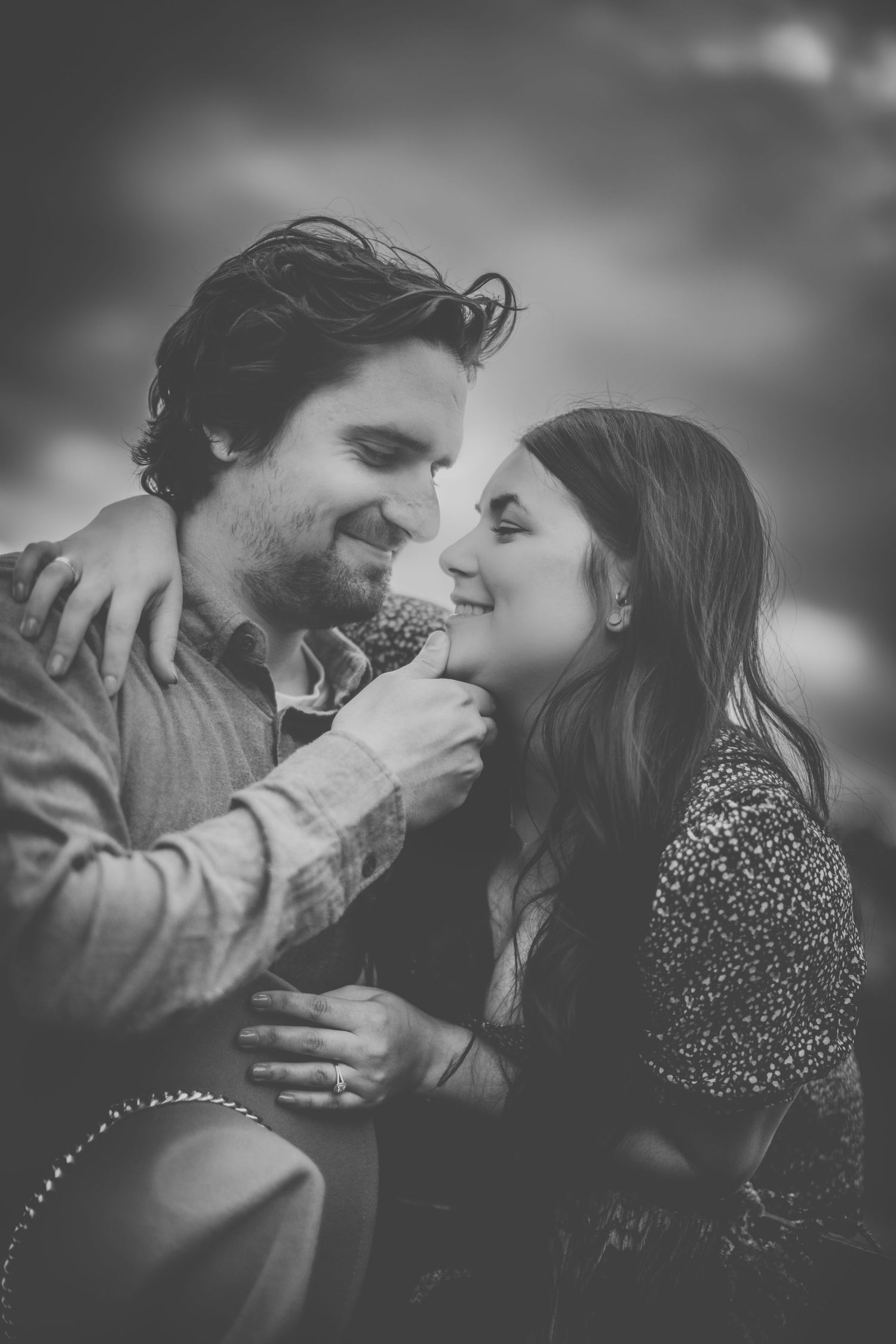 Black and white portrait of couple embracing and laughing together in a tender moment.
