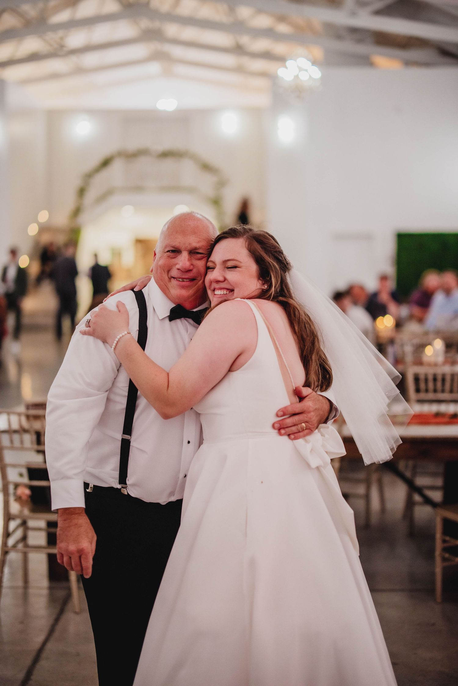 A candid moment of happiness between a bride and her dance partner during wedding festivities.