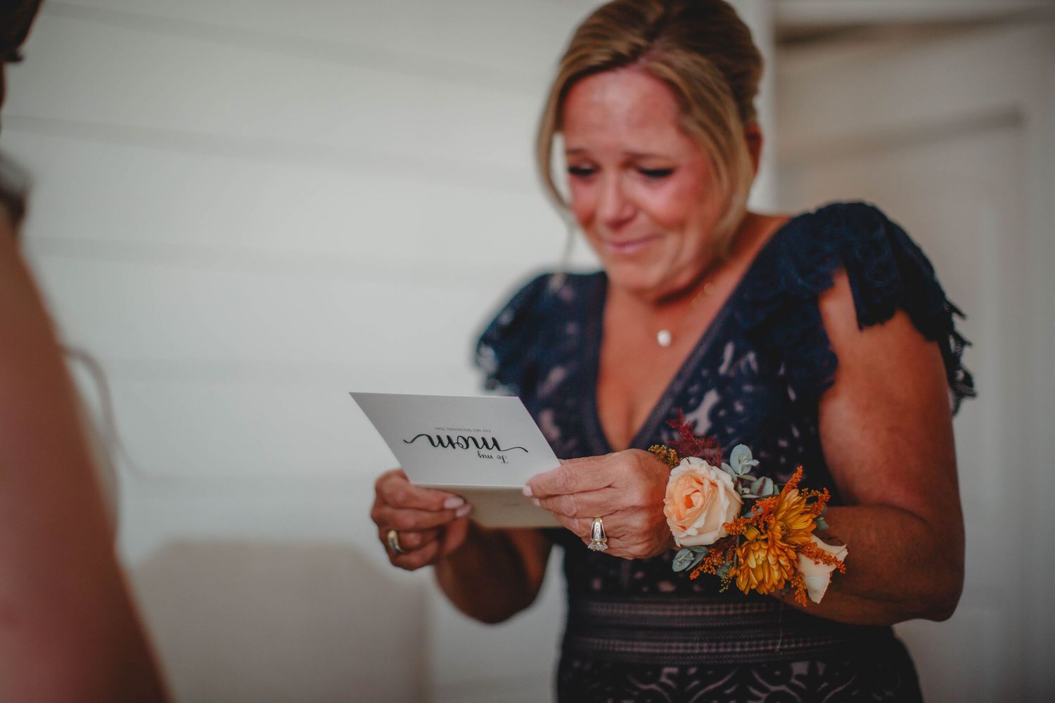 An emotional moment as someone reads from a card during wedding preparations.