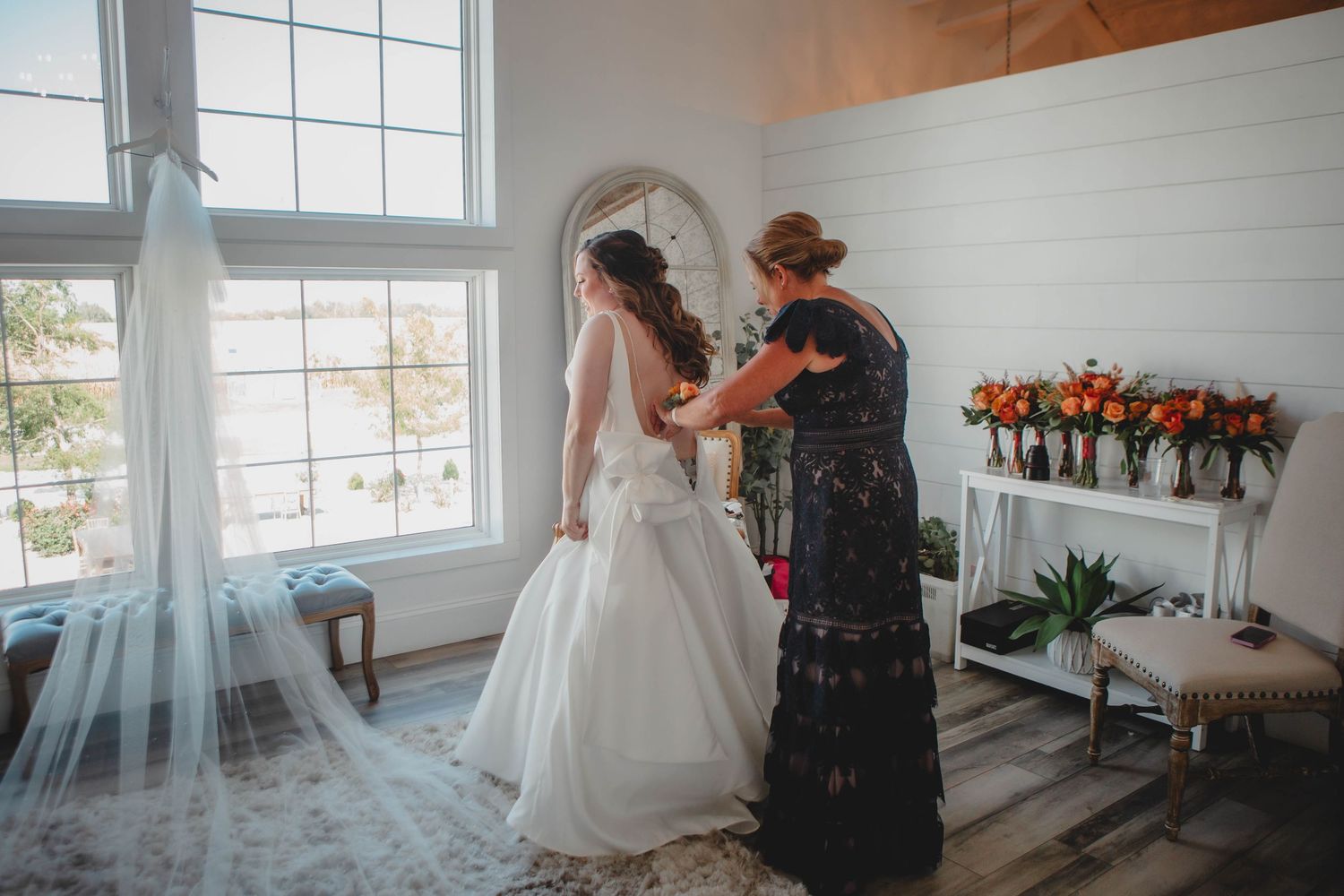 Bright modern wedding venue with large windows and white walls during a first look moment.