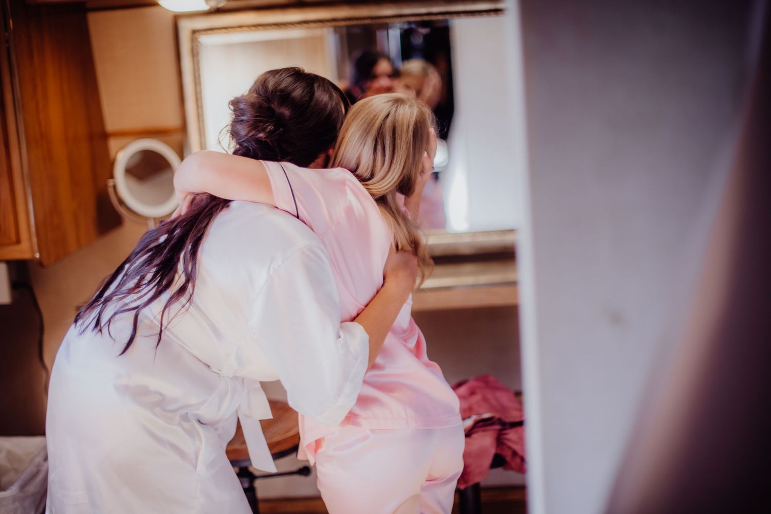 Wedding preparation scene with white robes in warm indoor lighting.